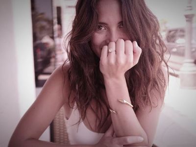 Adria Arjona has put her left hand on her face while showing the engagement ring.